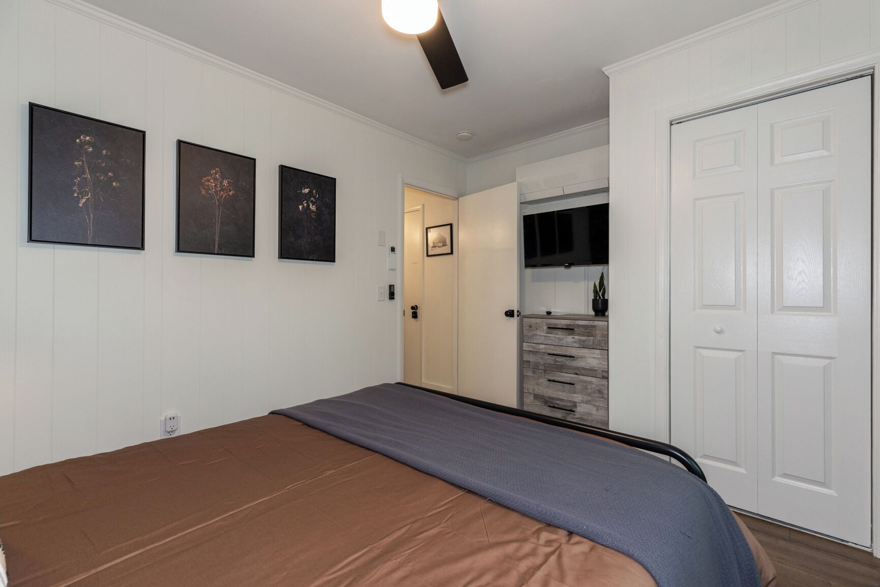 A bedroom with a bed, a wardrobe, and a door leading to a bathroom.