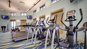 A gym with treadmills, elliptical machines, and a stationary bike.