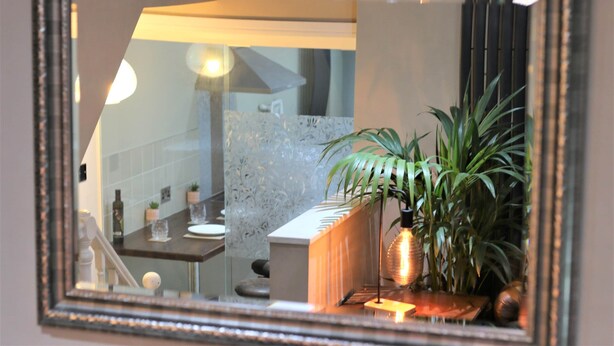 A mirror reflecting a bathroom with a sink, countertop, and potted plants. - Janet Street Loft (3 beds) (Cardiff)