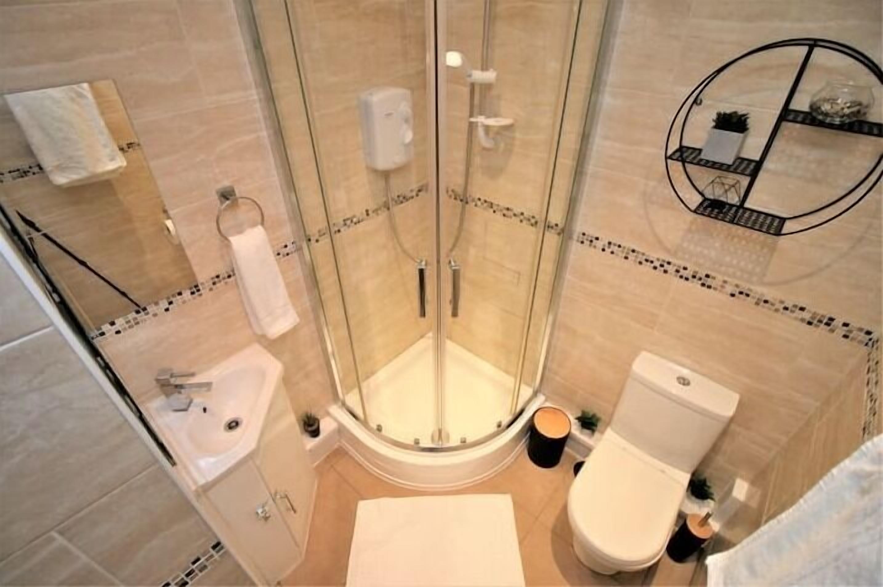 Une salle de bain moderne avec une douche à parois de verre, un lavabo et des toilettes.