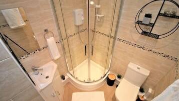 Une salle de bain moderne avec une douche à parois de verre, un lavabo et des toilettes.