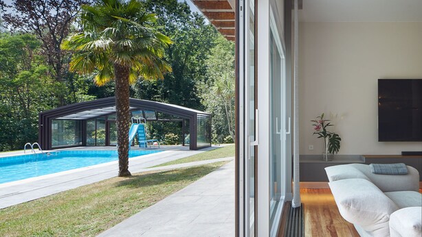 A modern home with a swimming pool, a covered outdoor area, and a living room with a TV and a plant. - Villa Jaizubia Golf by FeelFree Rentals (Hondarribia)