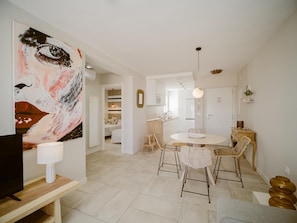 A modern interior with a dining area, a kitchen, and a living space.
