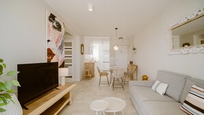 A modern living room with a TV, sofa, and dining area.