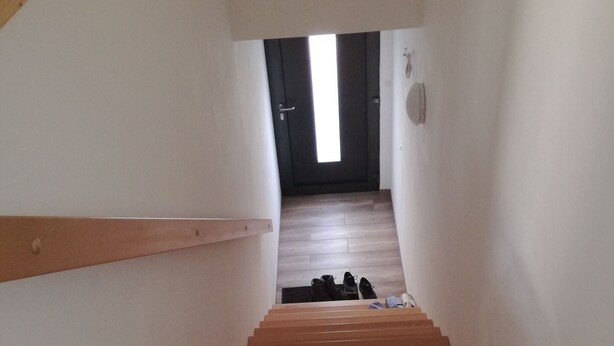 Una escalera de madera que sube a una habitación con una puerta.