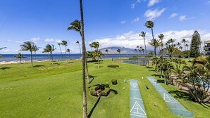 Un parcours de golf offrant une vue dégagée sur l’océan et les palmiers.