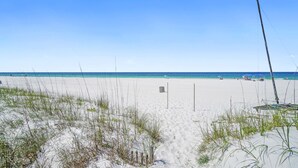 A sandy beach with a clear blue sky and ocean. - Beach House - Gulf Dream (Panama City Beach)