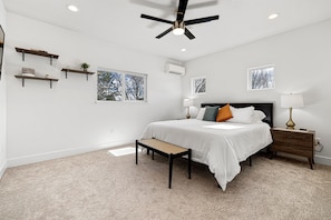 A modern bedroom with a large bed, bedside tables, a ceiling fan, and built-in shelves. - Minutes from downtown Boise and Boise State! (Boise)