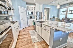 A modern kitchen with white cabinets, a granite countertop, and a stainless steel range hood. - Coastal Club Community * 19079 * w/ Resort-Style Amenities* 6 Br (Lewes)