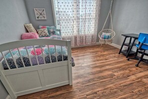 A room with a crib, a hanging chair, a small table, and a window with sheer curtains. - Coastal Club Community * 19079 * w/ Resort-Style Amenities* 6 Br (Lewes)