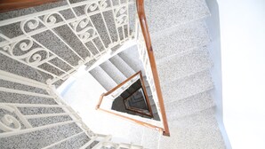 A spiral staircase with white metal railings and wooden steps.