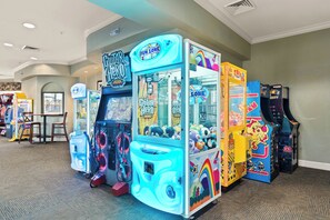 Een rij spelautomaten in een ruimte met vloerbedekking en een tafel met stoelen.
