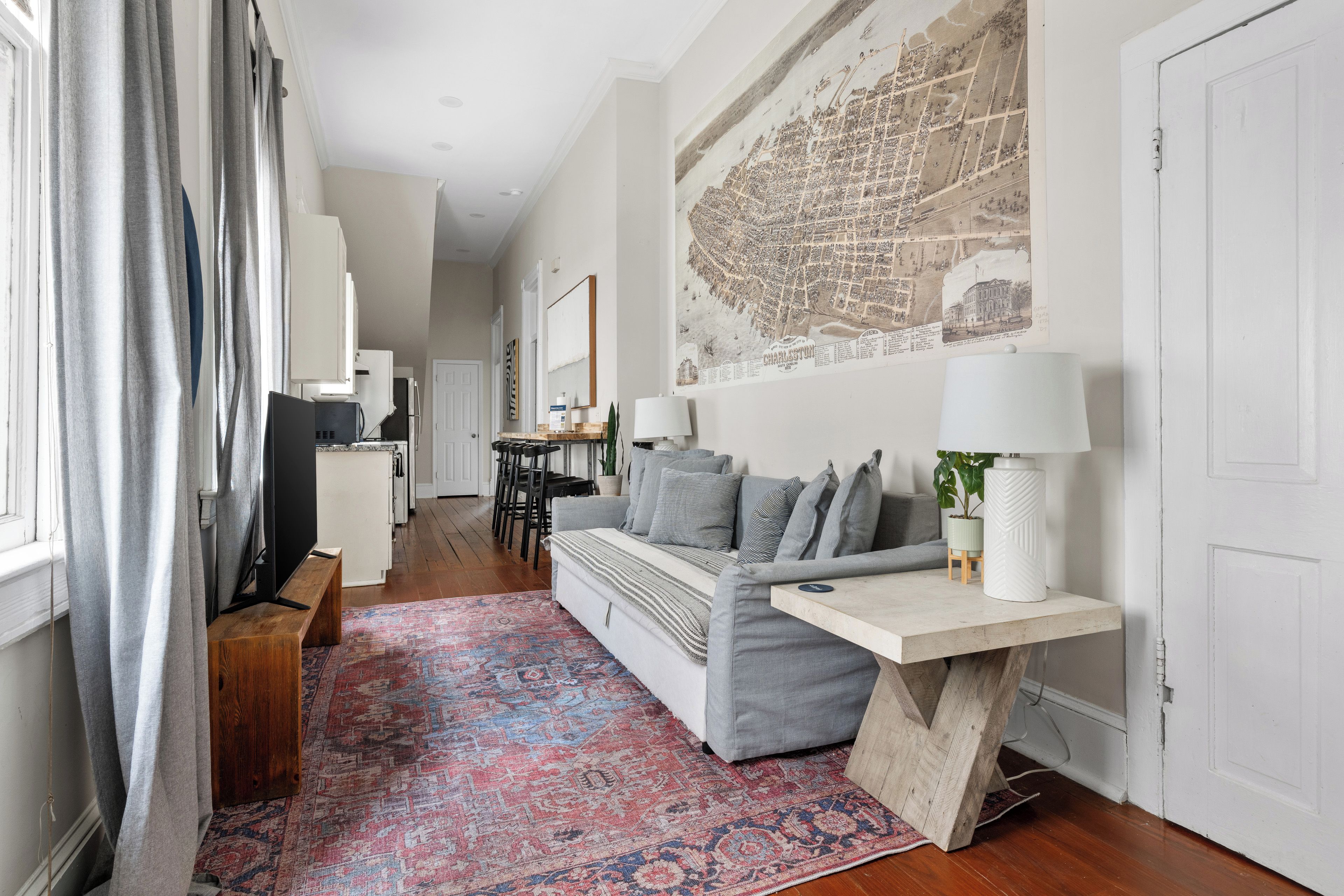 A modern living room with a sofa, a coffee table, and a map on the wall.