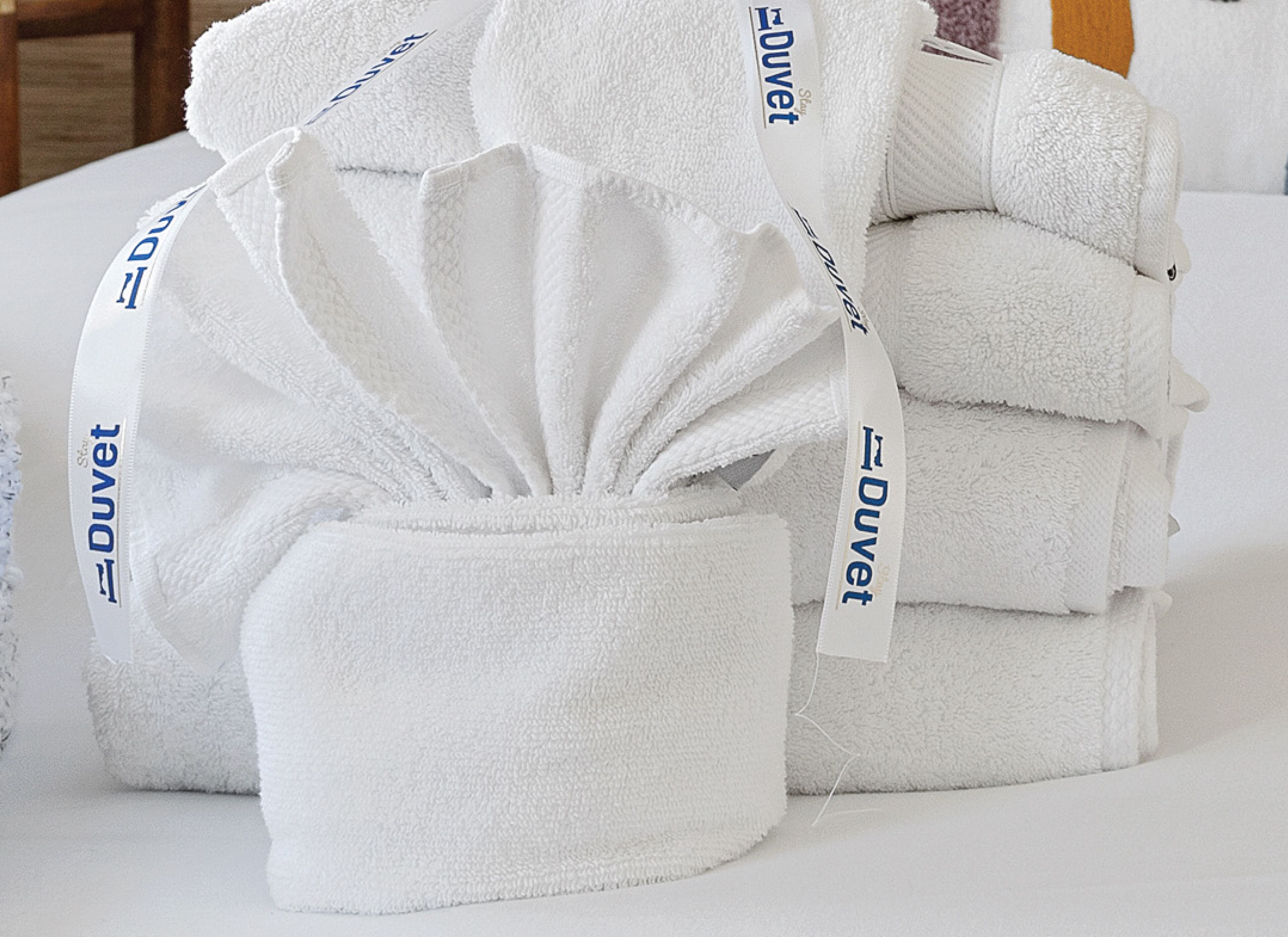 A stack of white towels with 'Duvet' branding.