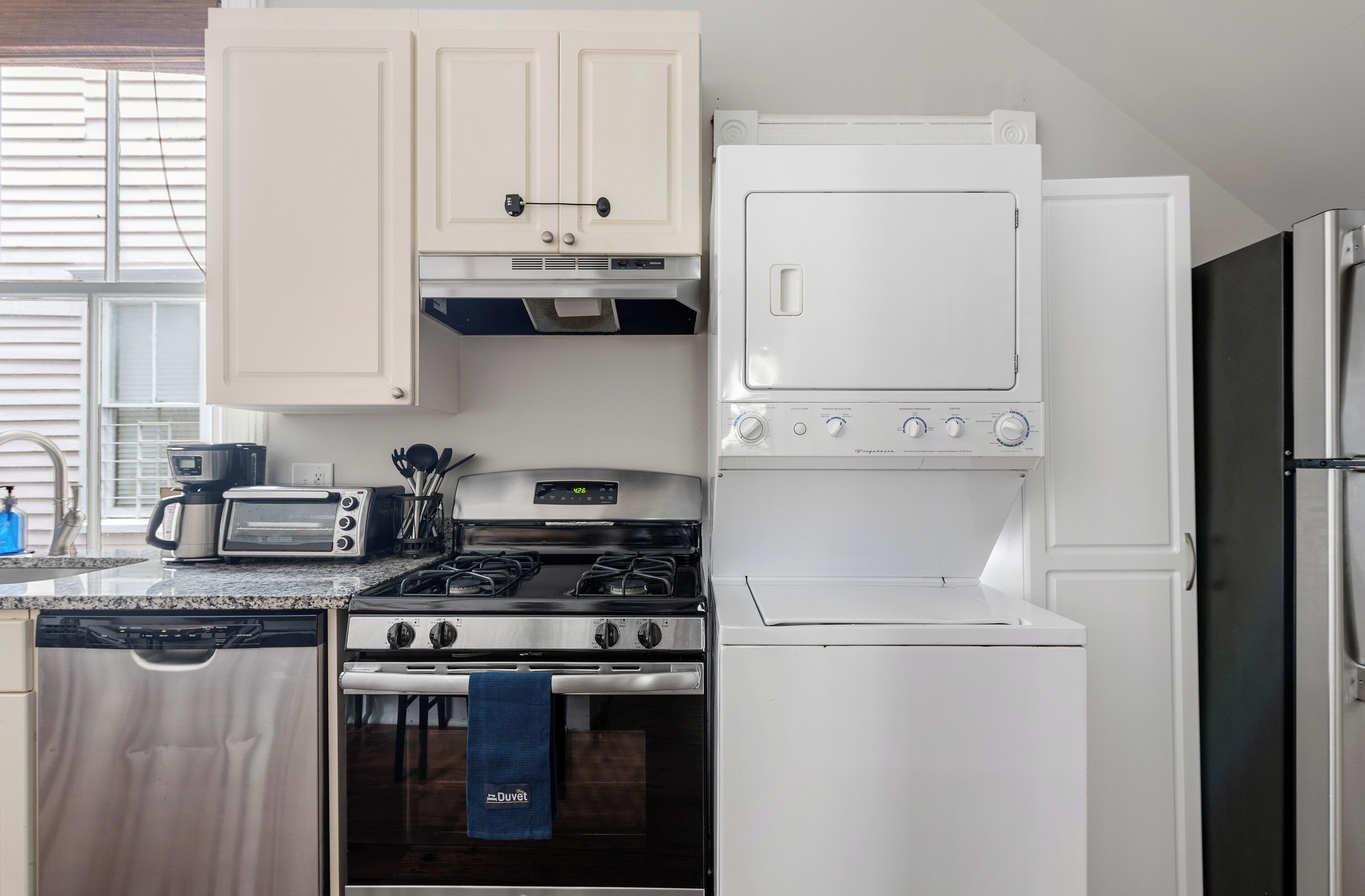 A kitchen with a dishwasher, stove, oven, toaster, and refrigerator.