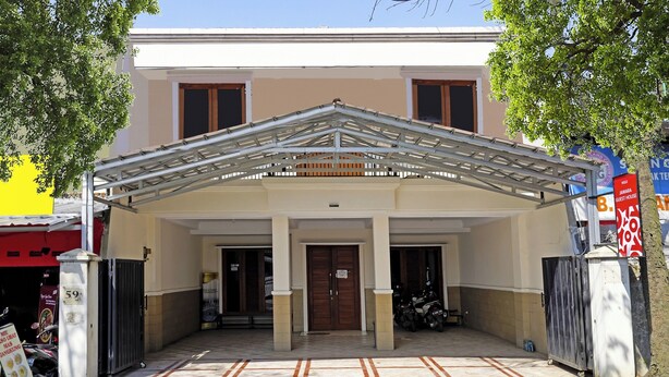 A two-story building with a covered entrance, a gated driveway, and a sign indicating it is a guest house. - OYO 91322 Jawara Guest House Syariah (Bandung)