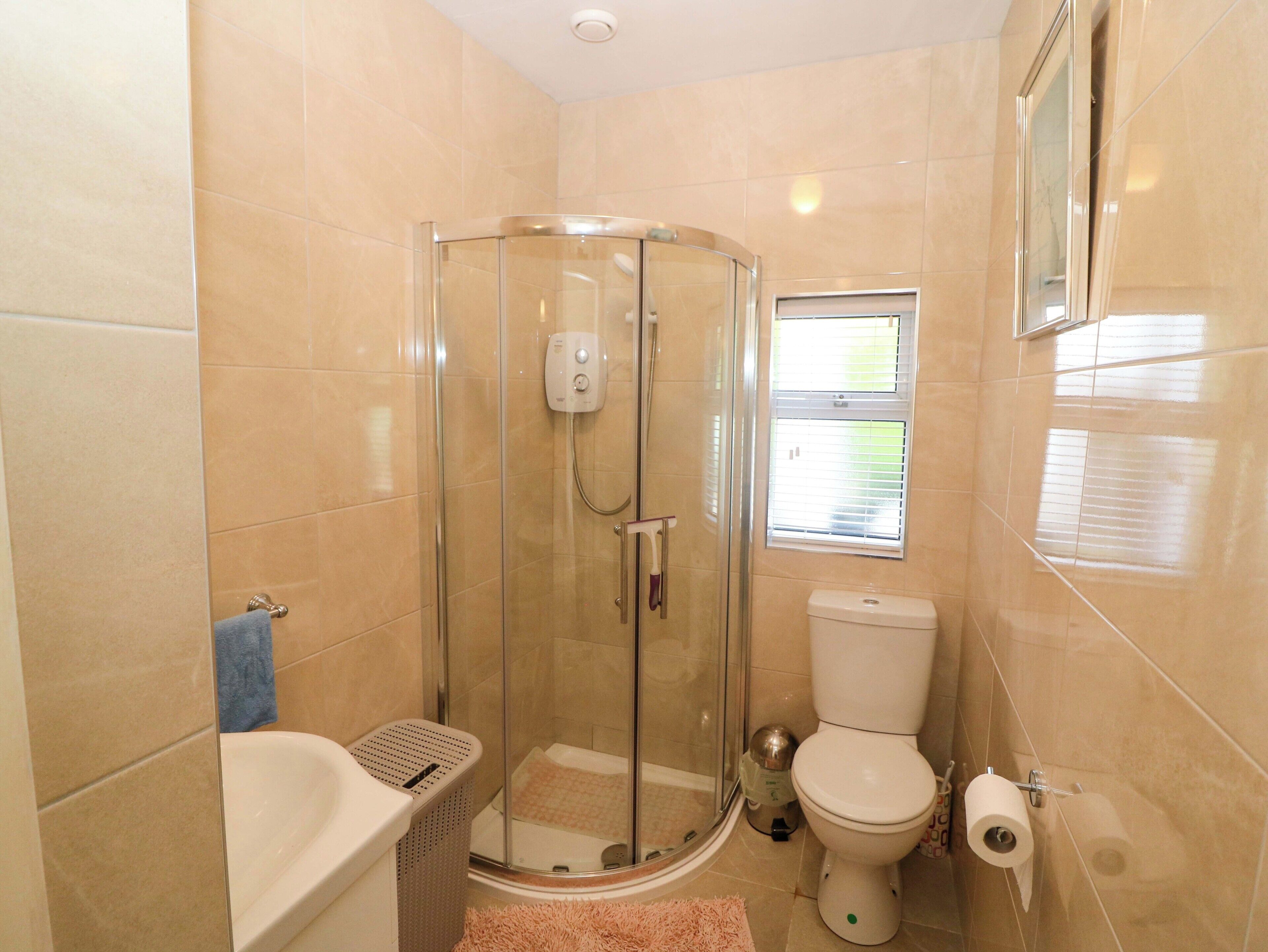 A bathroom with a glass-enclosed shower, a toilet, and a bathtub.