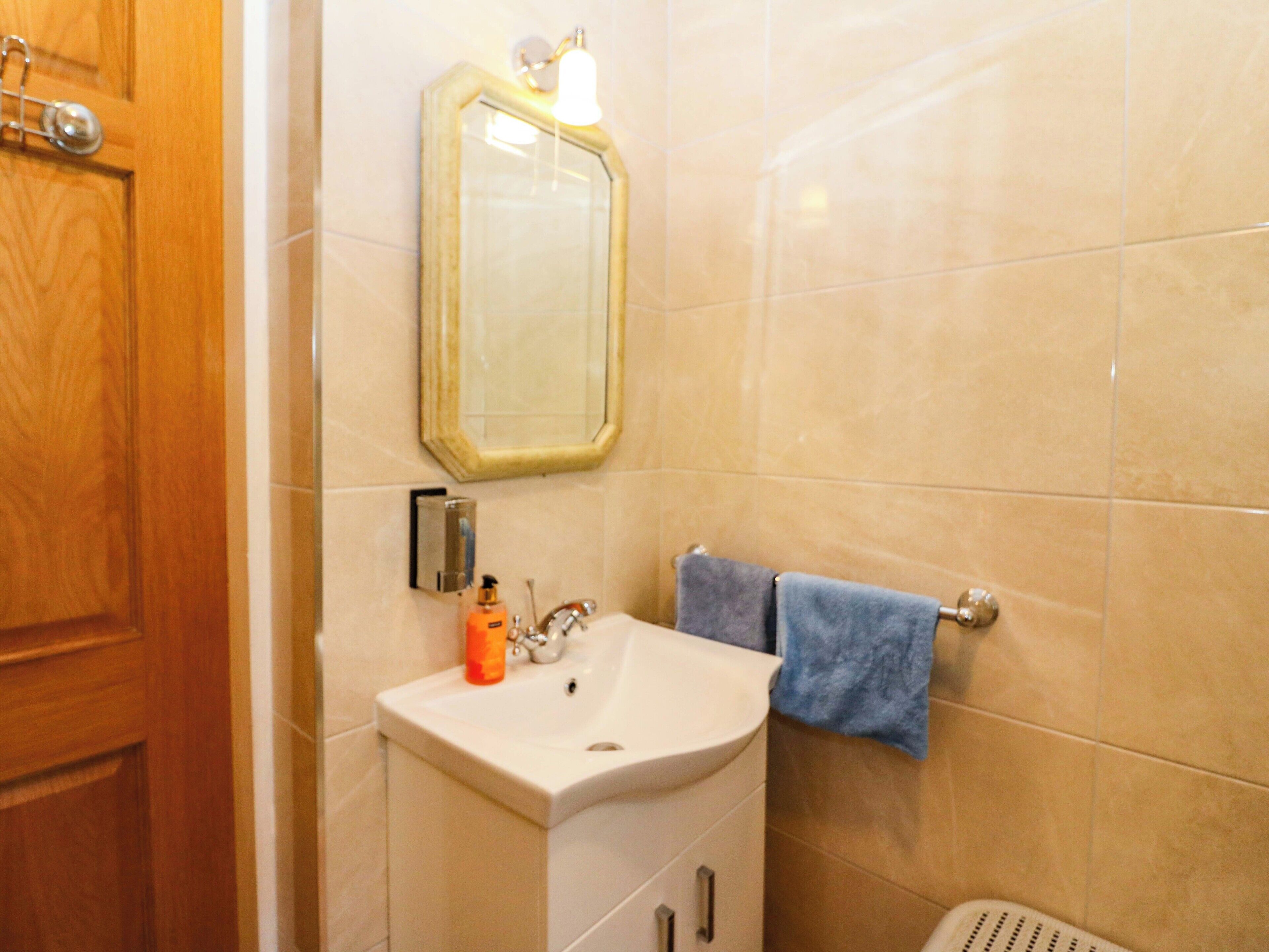 A bathroom with a sink, mirror, and towel rack.