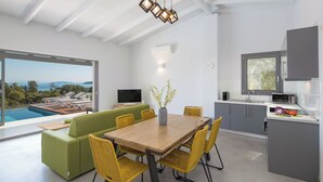 Uma cozinha moderna com área de jantar, uma janela ampla e vista para o exterior.