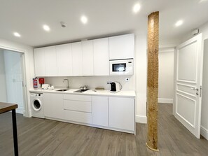 Una cocina moderna con electrodomésticos integrados, lavadora y microondas.