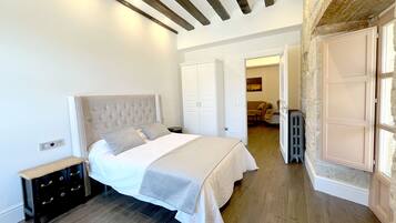 A bedroom with a bed, a nightstand, a wardrobe, and a radiator.