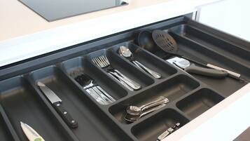 A drawer with utensils and a knife.
