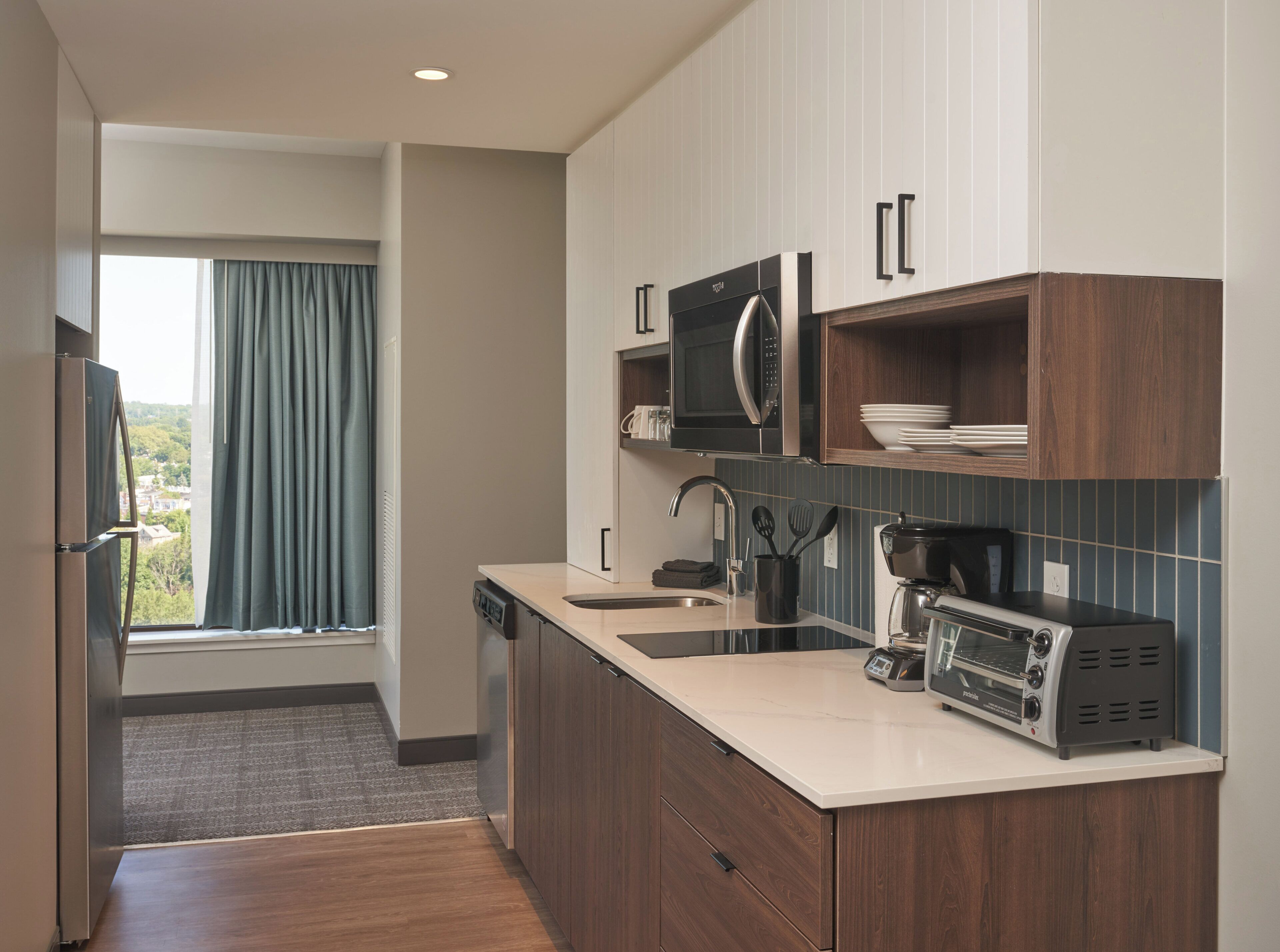 A modern kitchen with a built-in microwave, coffee maker, and a dishwasher.