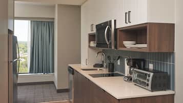 A modern kitchen with a built-in microwave, coffee maker, and a dishwasher.