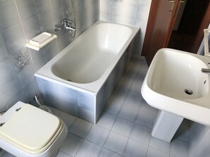 Ein Badezimmer mit einer Badewanne, einem Waschbecken und einer Toilette.