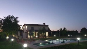A house with a swimming pool surrounded by grass and trees, with outdoor lighting. - Villa Domus Nirale, 4 km from Civita di Bagnoregio, panorama of Lake Bolsena. (Bagnoregio)
