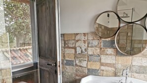 A bathroom with a white sink, a wooden door, and a tiled wall with multiple mirrors. - Villa Domus Nirale, 4 km from Civita di Bagnoregio, panorama of Lake Bolsena. (Bagnoregio)