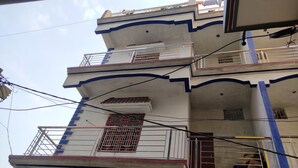 Um edifício com várias andares, varandas, guarda-corpos e uma escadaria visível.