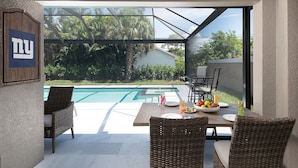 Eine Terrasse mit Pool, Korbmöbeln und einem New York-Schild.