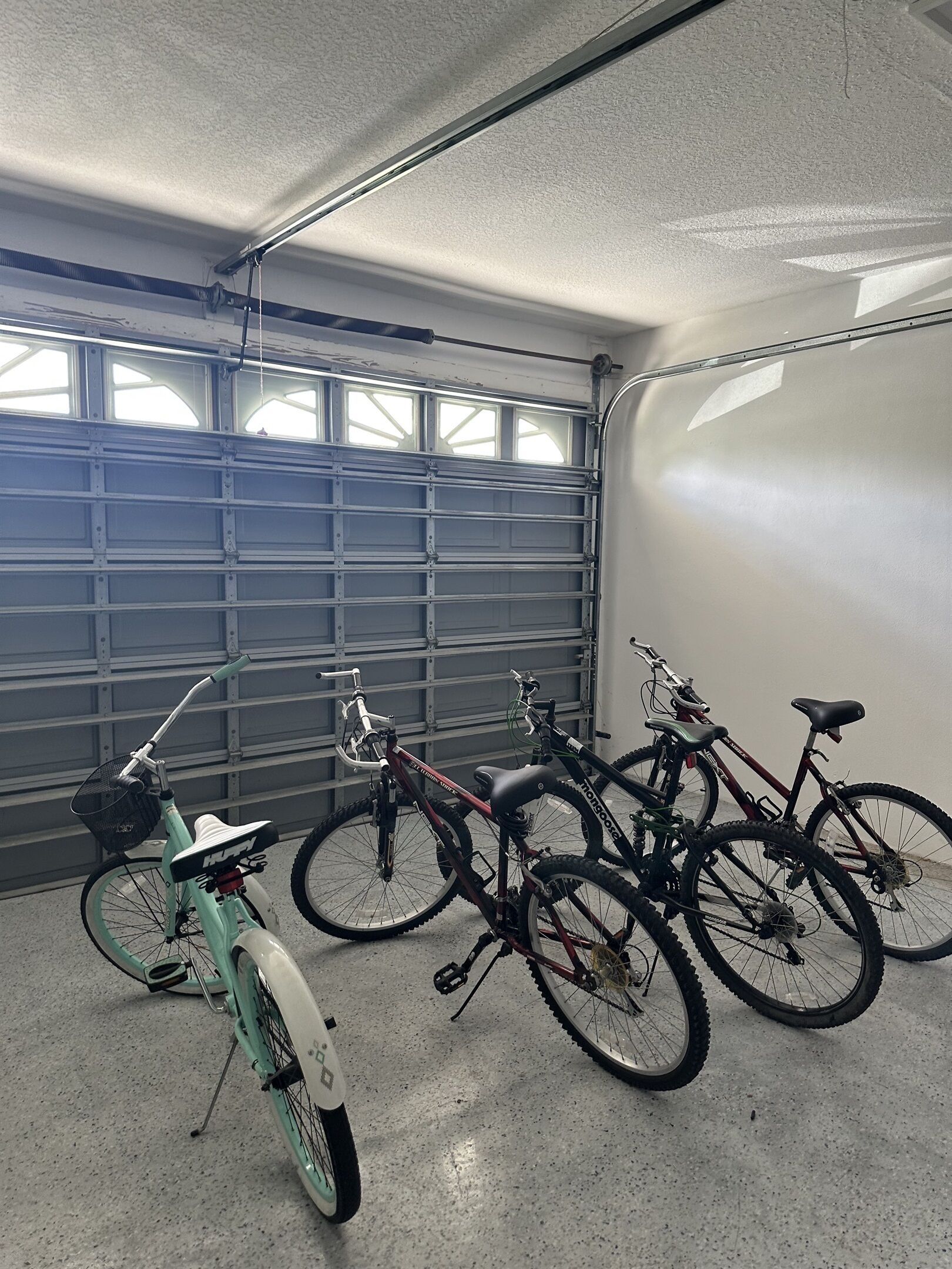 A garage with a concrete floor and a metal garage door.