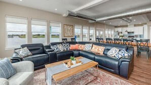 Ein geräumiges Wohnzimmer mit einer Eckcouch, einem Couchtisch und Blick ins Freie.