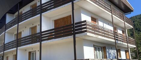 A multi-story building with balconies and a flat roof.