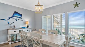 Un coin repas avec une table et des chaises en bois, un élément décoratif mural et une décoration en forme d’étoile de mer.