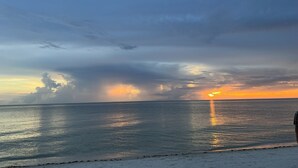 En strandscen med en klar himmel och ett lugnt hav.