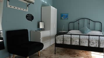 Une chambre à coucher avec un lit, une chaise, une armoire et un bureau.