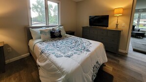 A bedroom with a bed, a dresser, a television, and a window. - Chesapeake Bay Loft Retreat, Walk to Water, Sleeps 2,  20 Min to Annapolis (Deale)