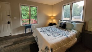 A bedroom with a bed, a nightstand, a lamp, a window, and a door. - Chesapeake Bay Loft Retreat, Walk to Water, Sleeps 2,  20 Min to Annapolis (Deale)