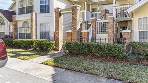 A two-story house with a brick facade, large windows, and a covered front porch. - Pool, Spa, Playground and More at Villas at Laguna Bay!! (Kissimmee)