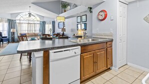 A spacious kitchen with a central island, wooden cabinets, and a built-in dishwasher. - Pool, Spa, Playground and More at Villas at Laguna Bay!! (Kissimmee)