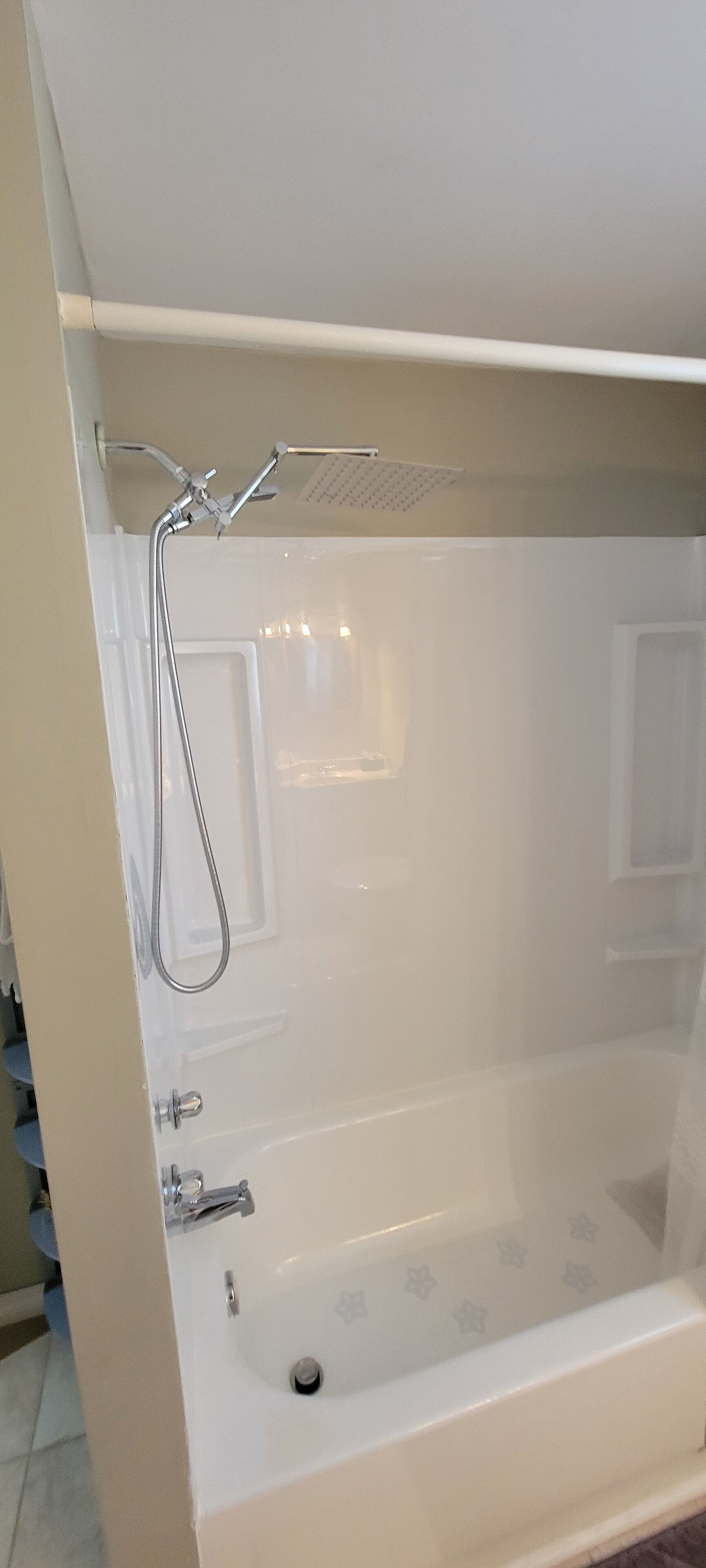 A bathtub with a showerhead and faucet, a window, and a door.