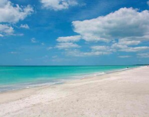 A beach with clear turquoise water and a wide sandy shore under a partly cloudy sky. - Beautiful Beach Longboat Key Townhouse (Longboat Key)