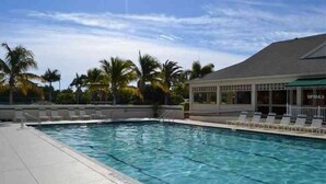 A swimming pool with clear water, surrounded by lounge chairs and palm trees. - Beautiful Beach Longboat Key Townhouse (Longboat Key)