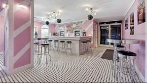 A bar area with a bar counter, stools, and a patterned floor. - 3 bedroom villa (Sleeps 8) in a tropical Tuscan style resort near Disney (Davenport)