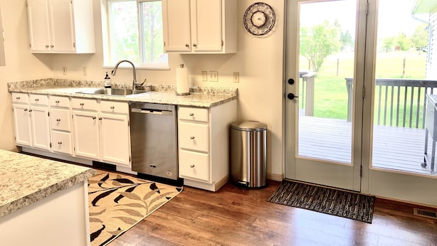 A kitchen with white cabinets, a stainless steel dishwasher, and a window. - Close to Glacier Park, Flathead Lake, Whitefish Mountain Resort (Kalispell)