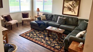 A living room with a sectional sofa, two armchairs, a coffee table, and a rug. - Close to Glacier Park, Flathead Lake, Whitefish Mountain Resort (Kalispell)