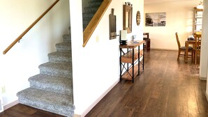 A staircase with a wooden handrail leading to a landing. A desk with a chair and a lamp is positioned near a wall with framed pictures. - Close to Glacier Park, Flathead Lake, Whitefish Mountain Resort (Kalispell)